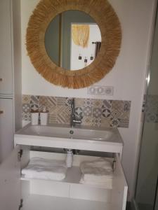 a bathroom with a sink and a mirror at Le Gîte insolite Gonnedouillé in Gonneville-en-Auge