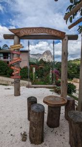 a park with a wooden bench and a sign at Villaggio Ronchi in Pedra Azul