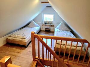 a attic room with two beds and a staircase at Ab unters Reet in Born