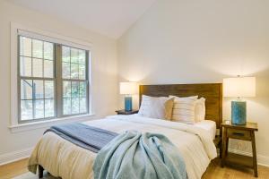 a white bedroom with a large bed with two lamps at Beautiful Raleigh Cottage Rental 5 Mi to Downtown in Raleigh