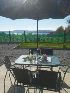 a table with chairs and an umbrella with a view at Lakeview farm 