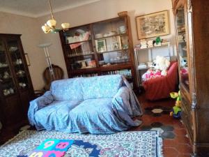 a living room with a blue couch in a room at Sweet Garden Maison de Charme in Thiesi