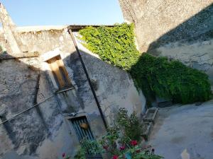 an old building with ivy growing on the side of it at Sweet Garden Maison de Charme in Thiesi