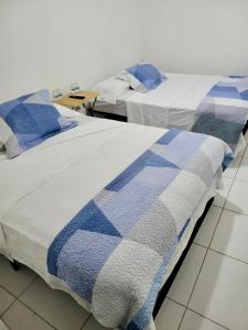 two beds sitting next to each other in a room at Residencial Lassonde Guest House in David