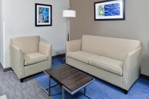 uma sala de estar com um sofá, uma cadeira e uma mesa em Holiday Inn Express Hotel & Suites St. Louis West-O'Fallon, an IHG Hotel em O'Fallon