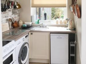 a kitchen with a washing machine and a sink at April Cottage in Gordon