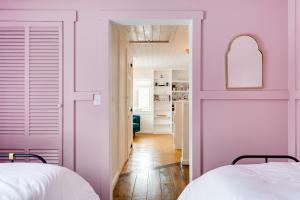 two beds in a room with pink walls at Rustic Mountain-View Farmhouse on 159 Acres in Lancaster