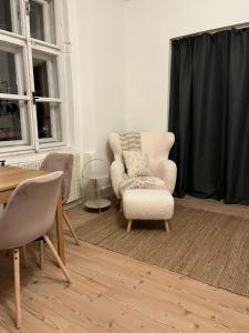 a living room with two chairs and a table at Cozy apartment close to Palmovka in Prague