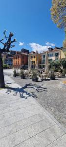 a parking lot with umbrellas and tables and buildings at Ca Angela in Mergozzo