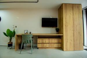 a room with a desk with a television on a wall at Barcelo Coliving in Medellín
