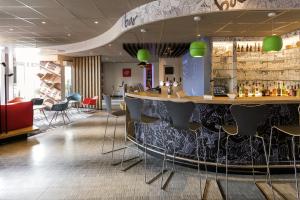 a bar in a restaurant with chairs and a counter at ibis Namur Centre in Namur