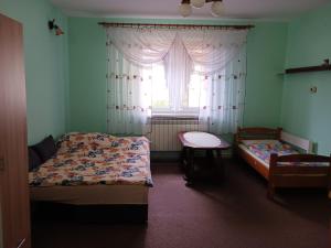 1 dormitorio con 2 camas y ventana en Jak w Domu en Lubaczów