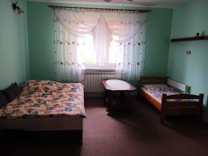 sypialnia z 2 łóżkami i oknem w obiekcie Jak w Domu w Lubaczowie