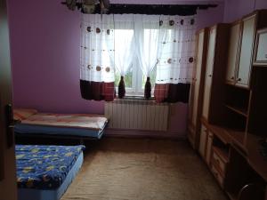 Habitación con 2 camas y ventana en Jak w Domu en Lubaczów