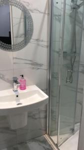 La salle de bains est pourvue d'un lavabo et d'une douche. dans l'établissement Grand Bleu - London - Next to Piccadilly Line Tube Station & Brand New Facilities, à Londres