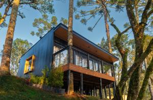 a house on a hill with trees at Green Barn Hotel & Bistro in Urubici
