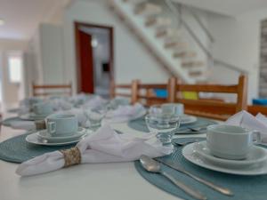una mesa con platos y tazas y una servilleta en 7 Heaven Arraial D'ajuda - Alto da Pitinga - Ararat, en Arraial d'Ajuda