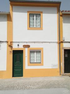 um edifício com uma porta verde e duas janelas em VillasMC no Alpalhão