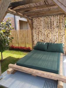 a bed in a backyard with a wooden pergola at Vikendica Dunja in Loznica