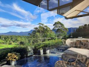 an outdoor patio with chairs and a view of the mountains at Ralphie’s Villa 2 bed 2 bath with Valley views in Kangaroo Valley