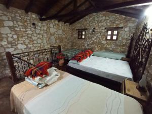 two twin beds in a room with a stone wall at Posada Filo Alto 