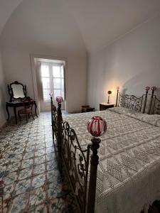 1 dormitorio con 1 cama con colcha blanca en Palazzo Triolo - Dimora di Charme, en Corleone