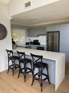 a kitchen with a counter with four chairs around it at Ralphie’s Villa 2 bed 2 bath with Valley views in Kangaroo Valley