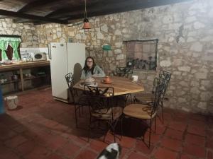 una mujer sentada en una mesa en una cocina en Posada Filo Alto, 