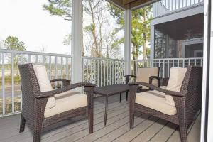 two wicker chairs and a table on a porch at Rehoboth Crossing - Beach Oasis! in Rehoboth Beach