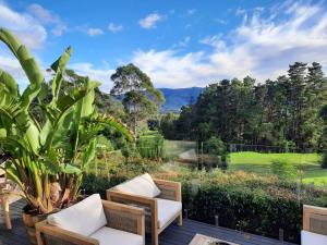 a patio with two chairs and a view of a golf course at Ralphie’s Villa 2 bed 2 bath with Valley views in Kangaroo Valley