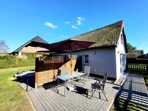 a patio with a table and chairs and an umbrella at Ab unters Reet in Born