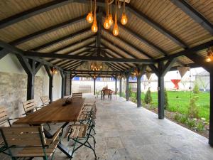 a wooden pavilion with a wooden table and benches at Casa Dor de Lac in Salcioara