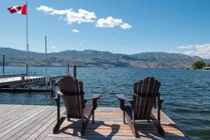 two chairs sitting on a dock next to the water at Lake House at Quails' Gate Winery in West Kelowna