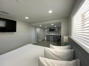 um quarto com uma cama branca com almofadas e uma cozinha em Amoray Dive Resort em Key Largo