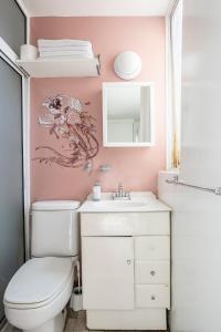 bagno con servizi igienici, lavandino e specchio di Increible departamento en la del valle a Città del Messico