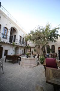 une cour avec des bancs et une fontaine dans un bâtiment dans l'établissement Tessera Hotel, à Şanlıurfa