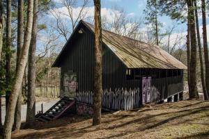a black building with graffiti on it in the woods at Camp Swann in Tracy City