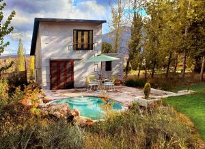 una casa con una pequeña piscina en el patio en Hidden Twins Casitas de montaña de alquiler en Cacheuta