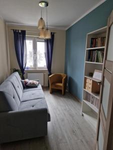 a living room with a couch and a window at Słoneczny Apartament in Suwałki