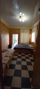 a bedroom with two beds and a checkered floor at ВИКЕНД in Karolino-Buhaz