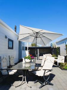 a table and chairs with an umbrella on a patio at Sandy Feet Retreat in Petten