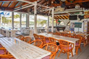 Koukias Village في ترولو: مطعم فارغ بطاولات وكراسي خشبية
