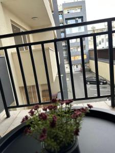 een vaas met bloemen op een tafel op een balkon bij Red Corner Central Apartment in Cluj-Napoca +14 foto's