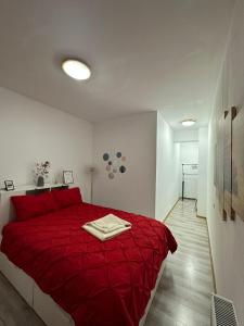 een slaapkamer met een rood bed en een rode deken bij Red Corner Central Apartment in Cluj-Napoca