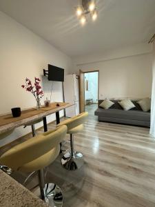 een woonkamer met een tafel, stoelen en een bank bij Red Corner Central Apartment in Cluj-Napoca
