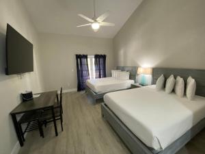 1 dormitorio con 2 camas, escritorio y TV en Amoray Dive Resort en Key Largo