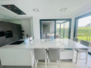 a kitchen with a large white counter and chairs at rainbow house 