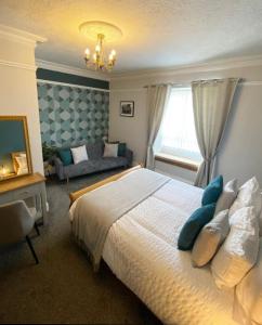 een slaapkamer met een groot bed en een bank bij The Dial inn in Lamphey