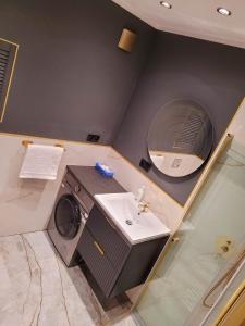 a bathroom with a washing machine and a sink at Justinrent 1 in Legnica