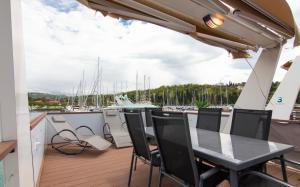 a balcony with a table and chairs on a boat at Floating House Adela in Portorož